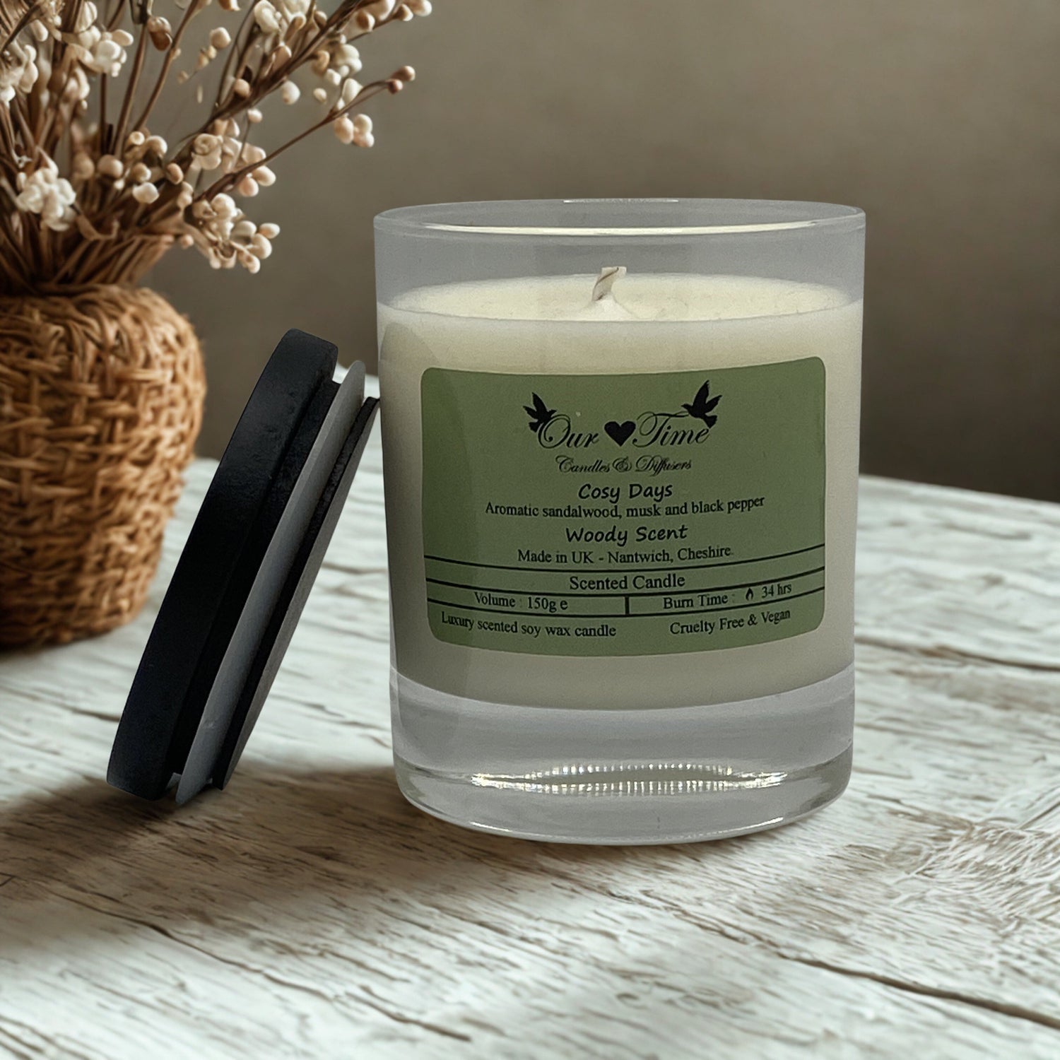 Medium candle with a black lid on a wooden surface